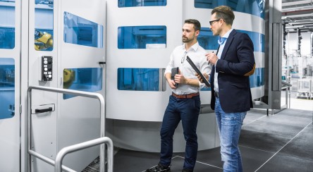 Men discuss in the production hall