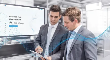 在展会现场的 Festo 展位上，一位专家向客户讲解虚拟助手的功能。