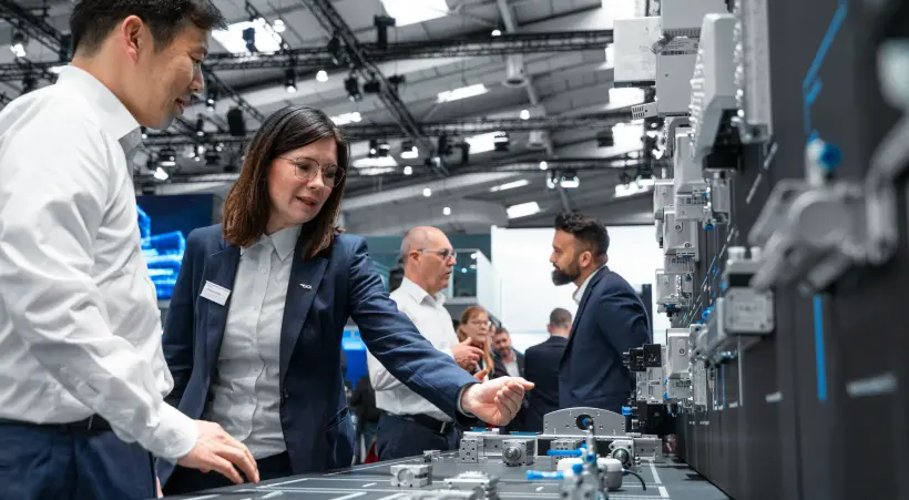 A Festo expert explains a tailored automation solution at the product wall on the Festo booth.