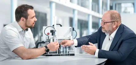 Two persons speaking about market-ready devices