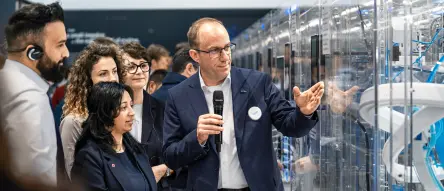A Festo tour guide explains the Incredible Machine to Hannover Messe customers.