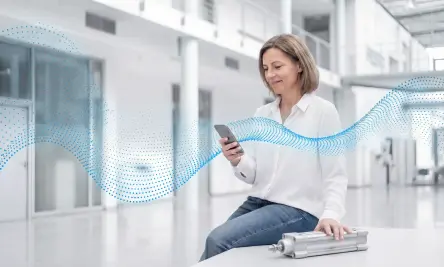 A woman is pleased with the product information about her cylinder that the Festo Virtual Assistant delivered on her smartphone.